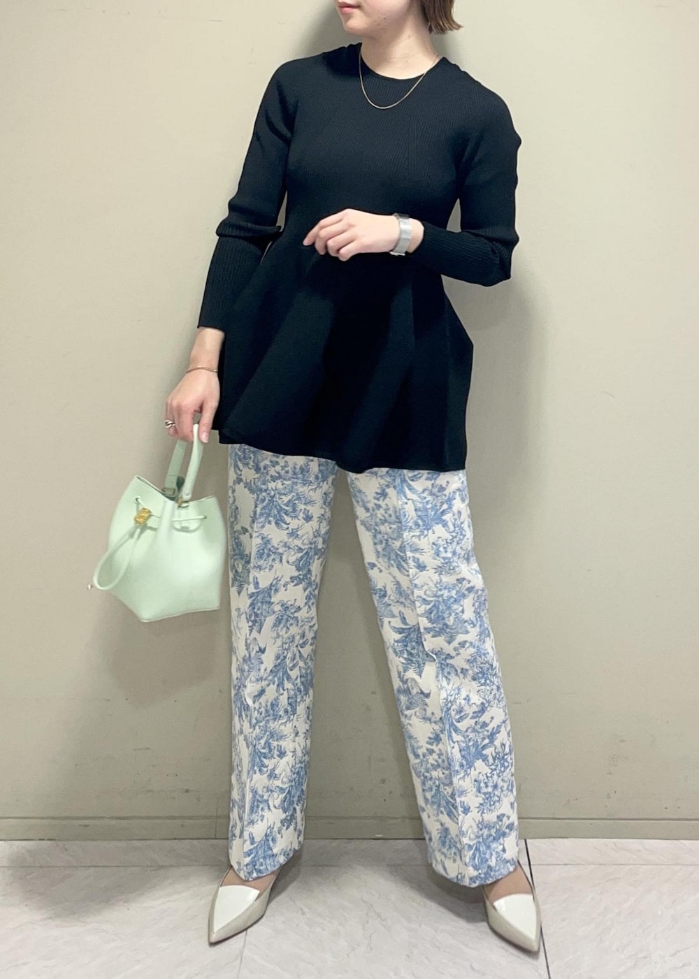 グリーン系のハンドバッグ、ブラック系のニット/セーター、ブルー系のその他パンツを着用したレディースの冬コーディネートの4枚目の写真