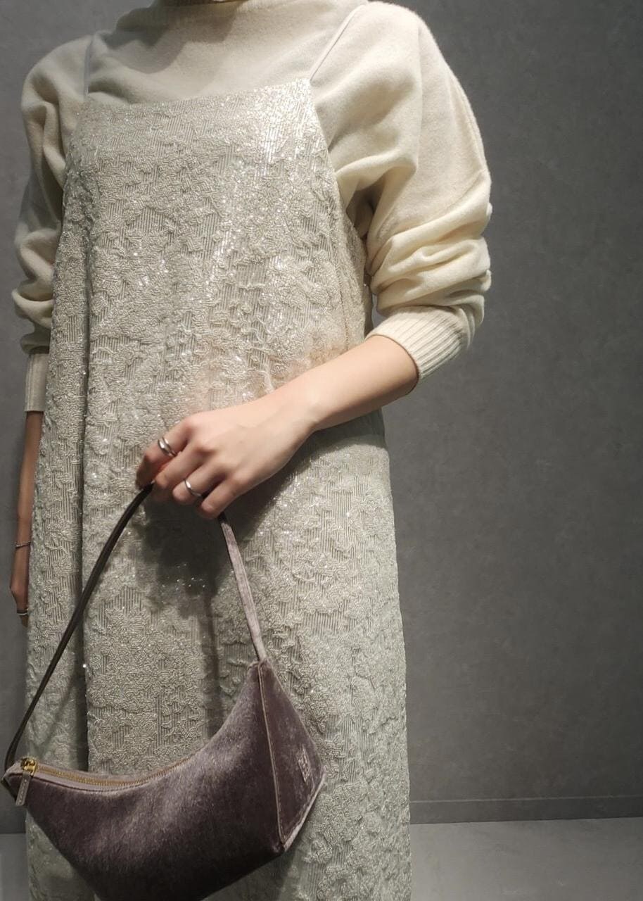 ブルー系のデニムパンツ、グレー系のハンドバッグ、ホワイト系のワンピースを着用したレディースの冬コーディネートの5枚目の写真