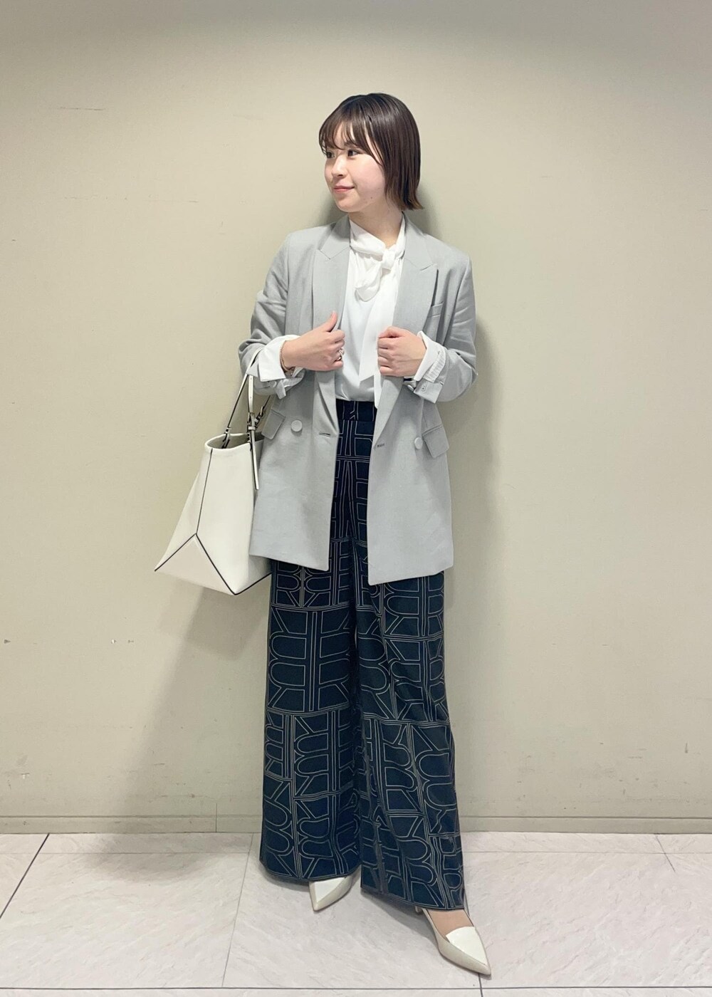 ブラック系のその他パンツ、ホワイト系のシャツ/ブラウス、ホワイト系のトートバッグを着用したレディースの冬コーディネートの2枚目の写真