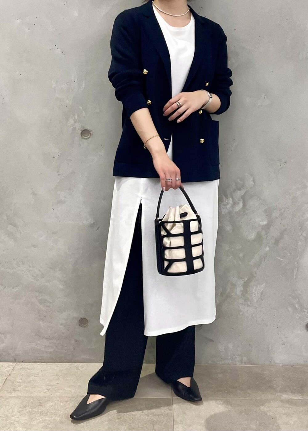ブラック系のハンドバッグ、ブルー系のテーラードジャケット、ブラック系のその他パンツを着用したレディースの春コーディネートの2枚目の写真