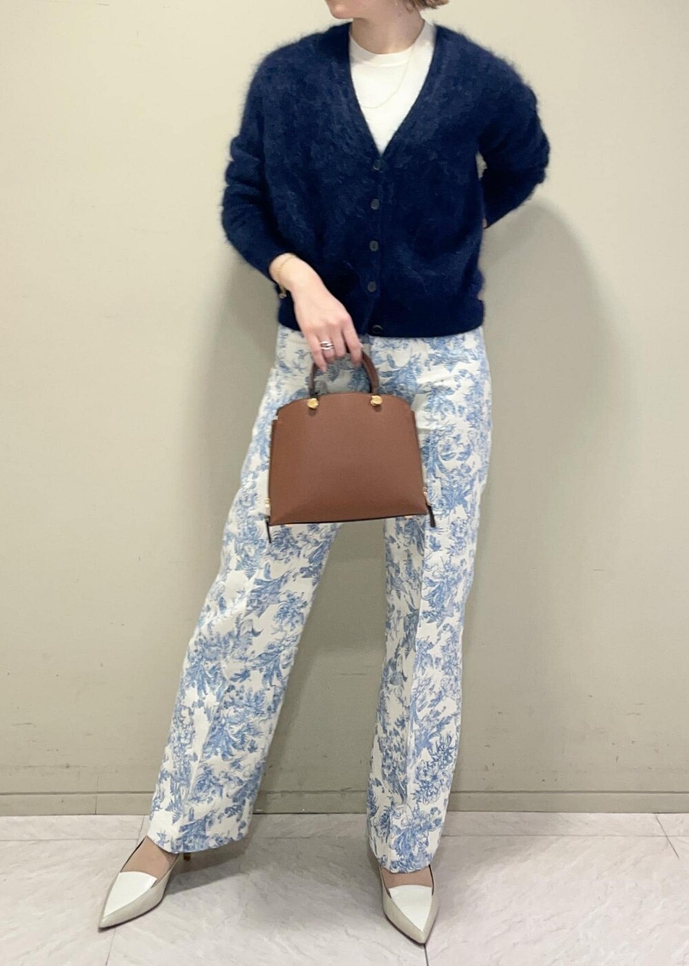 ブラウン系のハンドバッグ、ホワイト系のニット/セーター、ブルー系のその他パンツを着用したレディースの冬コーディネートの2枚目の写真
