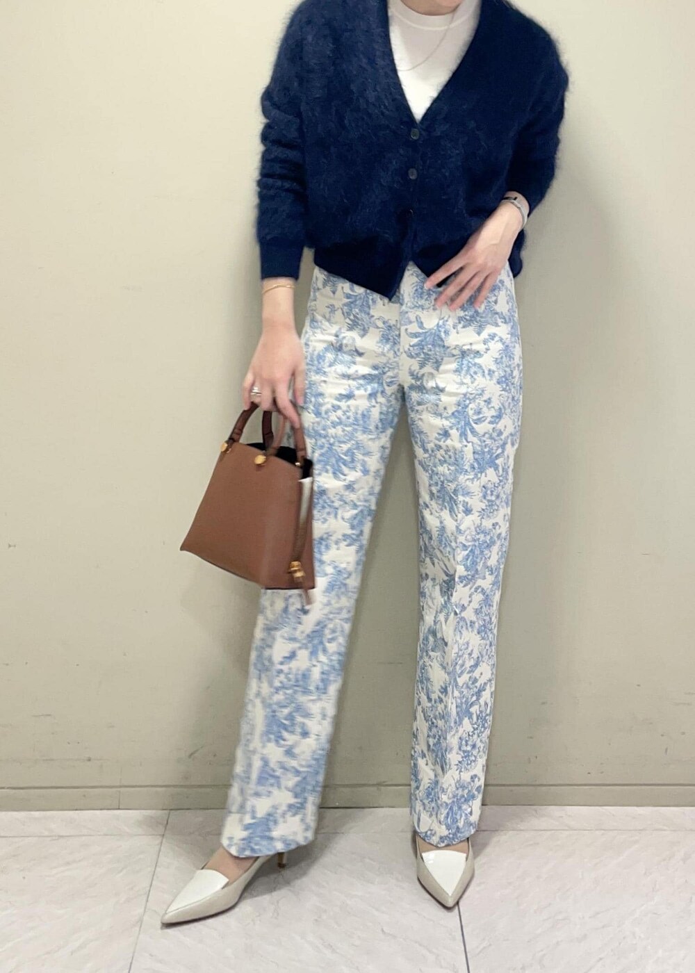 ブラウン系のハンドバッグ、ホワイト系のニット/セーター、ブルー系のその他パンツを着用したレディースの冬コーディネートの3枚目の写真