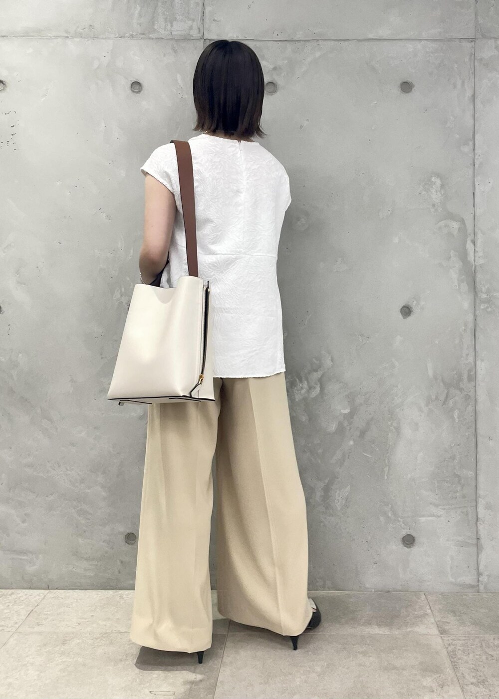 ホワイト系のショルダーバッグ、ブラック系のパンプス、ホワイト系のシャツ/ブラウスを着用したレディースの春コーディネートの2枚目の写真