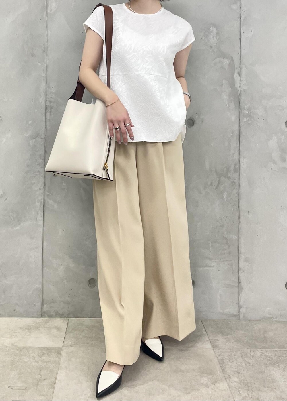 ホワイト系のショルダーバッグ、ブラック系のパンプス、ホワイト系のシャツ/ブラウスを着用したレディースの春コーディネートの5枚目の写真