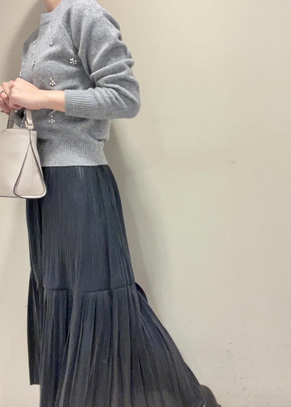 ブラック系のブーツ、ブラック系のスカート、ベージュ系のショルダーバッグを着用したレディースの秋コーディネートの9枚目の写真