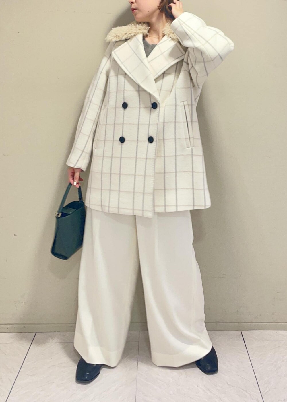 ホワイト系のチェスターコート、グリーン系のショルダーバッグ、ブラウン系のニット/セーターを着用したレディースの秋コーディネートの3枚目の写真