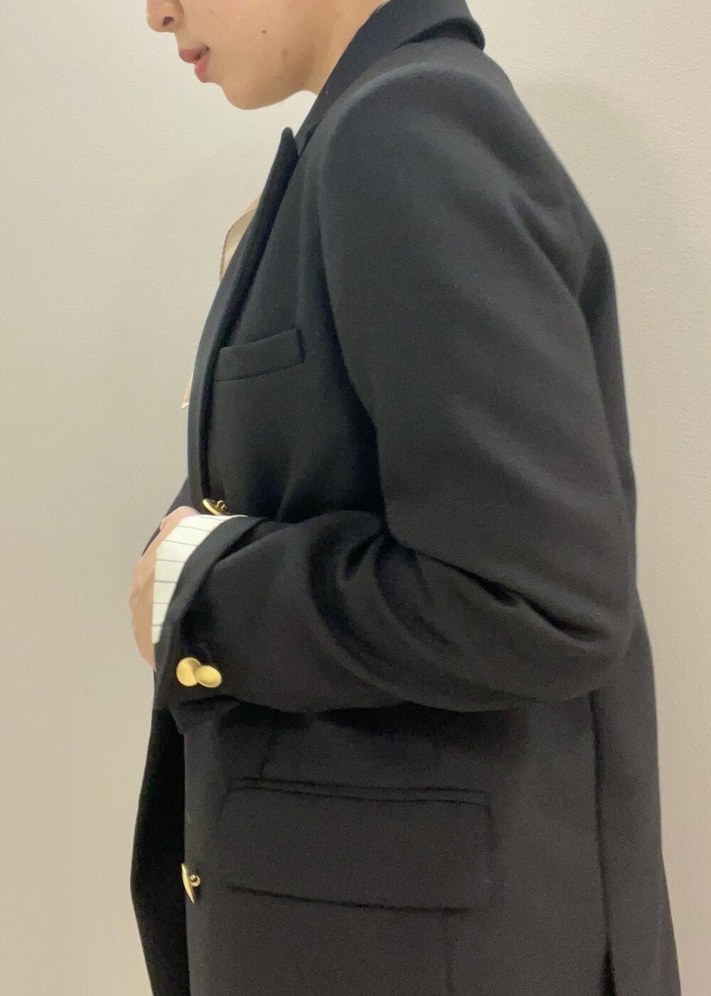 ブルー系のテーラードジャケット、イエロー系のハンドバッグ、ブラック系のブーツを着用したレディースの秋コーディネートの8枚目の写真