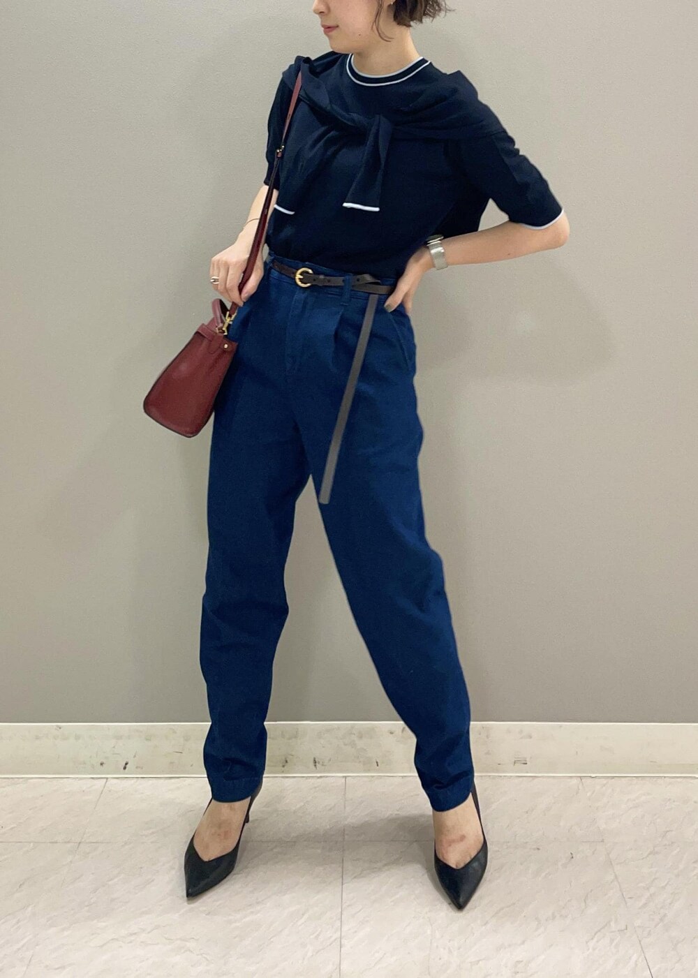 レッド系のショルダーバッグ、ブルー系のカーディガン/ボレロ、ブラック系のパンプスを着用したレディースの夏コーディネートの4枚目の写真