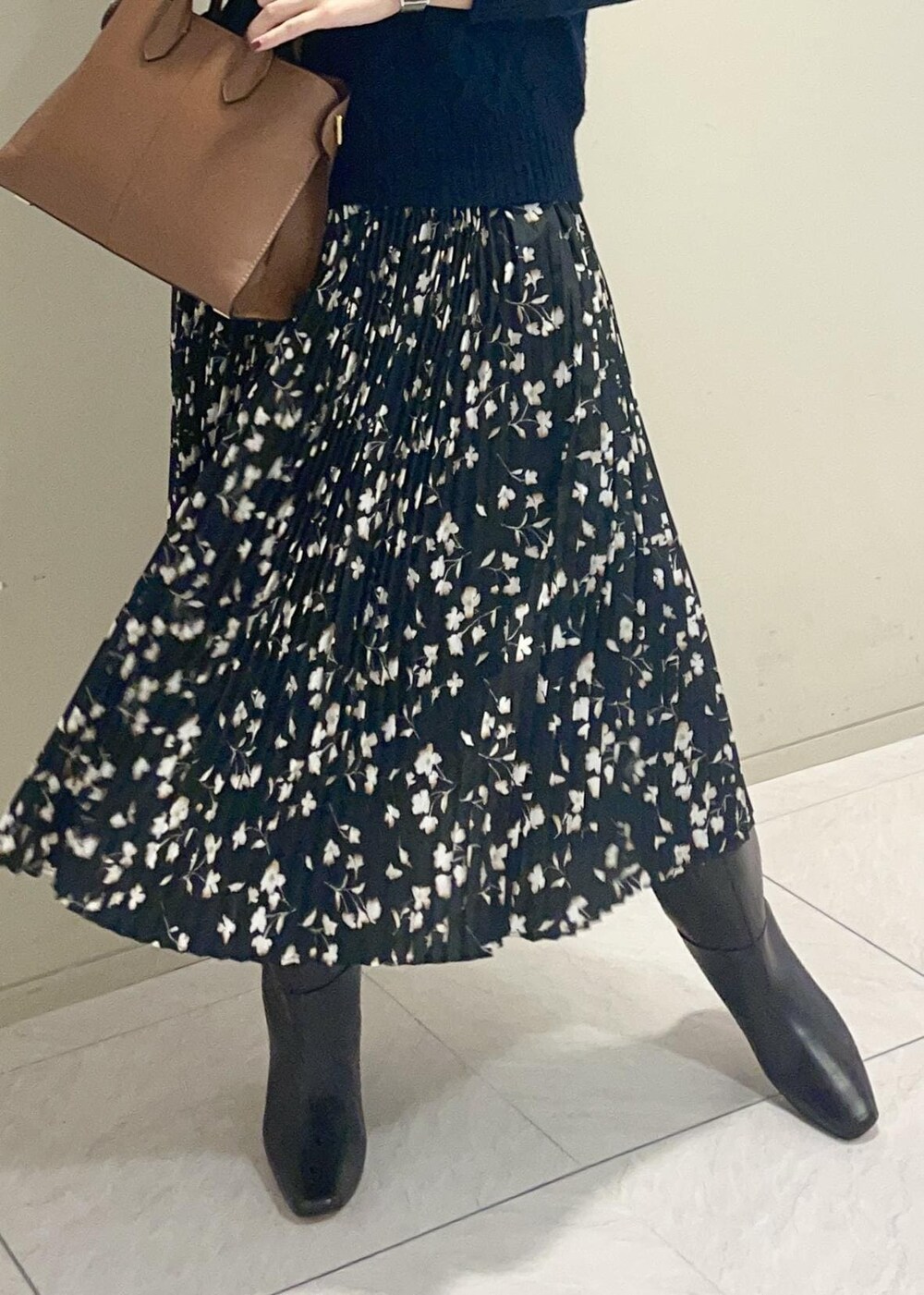 ブラウン系のブーツ、イエロー系のトートバッグ、ブラック系のスカートを着用したレディースの秋コーディネートの7枚目の写真