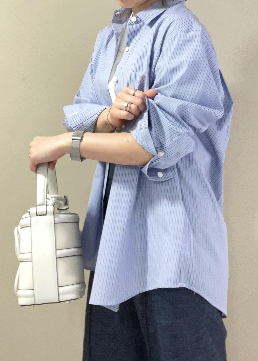 ホワイト系のハンドバッグ、ブルー系のデニムパンツ、ブルー系のシャツ/ブラウスを着用したレディースの春コーディネートの7枚目の写真