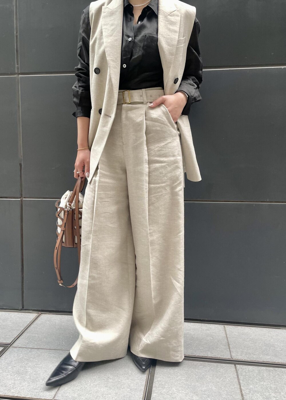 ブラック系のパンプス、ブラック系のシャツ/ブラウス、ベージュ系のベストを着用したレディースの春コーディネートの7枚目の写真