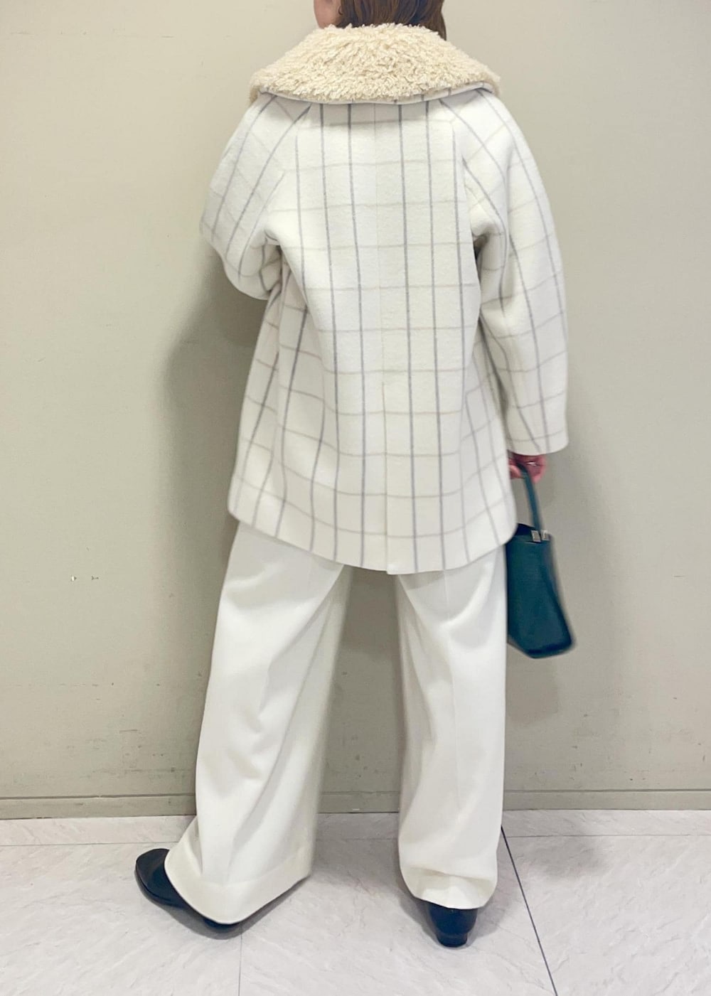 ホワイト系のチェスターコート、グリーン系のショルダーバッグ、ブラウン系のニット/セーターを着用したレディースの秋コーディネートの6枚目の写真