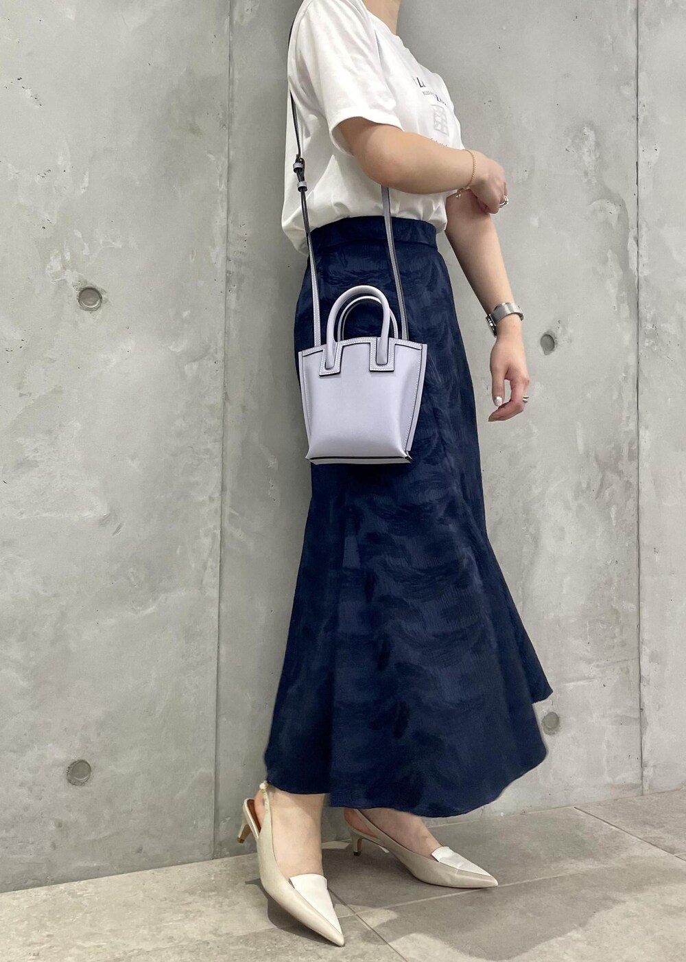 ベージュ系のパンプス、ブルー系のスカート、ホワイト系のTシャツ/カットソーを着用したレディースの春コーディネートの6枚目の写真