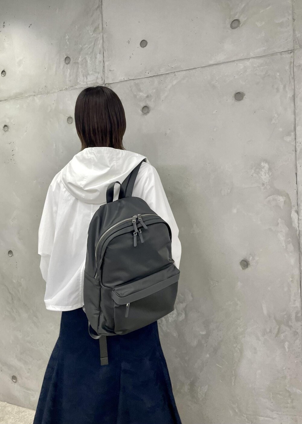 ベージュ系のパンプス、ブルー系のスカート、ホワイト系のマウンテンパーカーを着用したレディースの春コーディネートの7枚目の写真