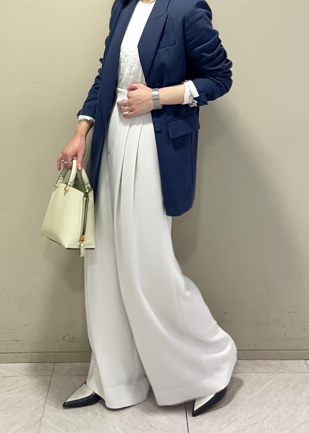 ホワイト系のその他パンツ、グリーン系のハンドバッグ、ブラック系のパンプスを着用したレディースの春コーディネートの4枚目の写真