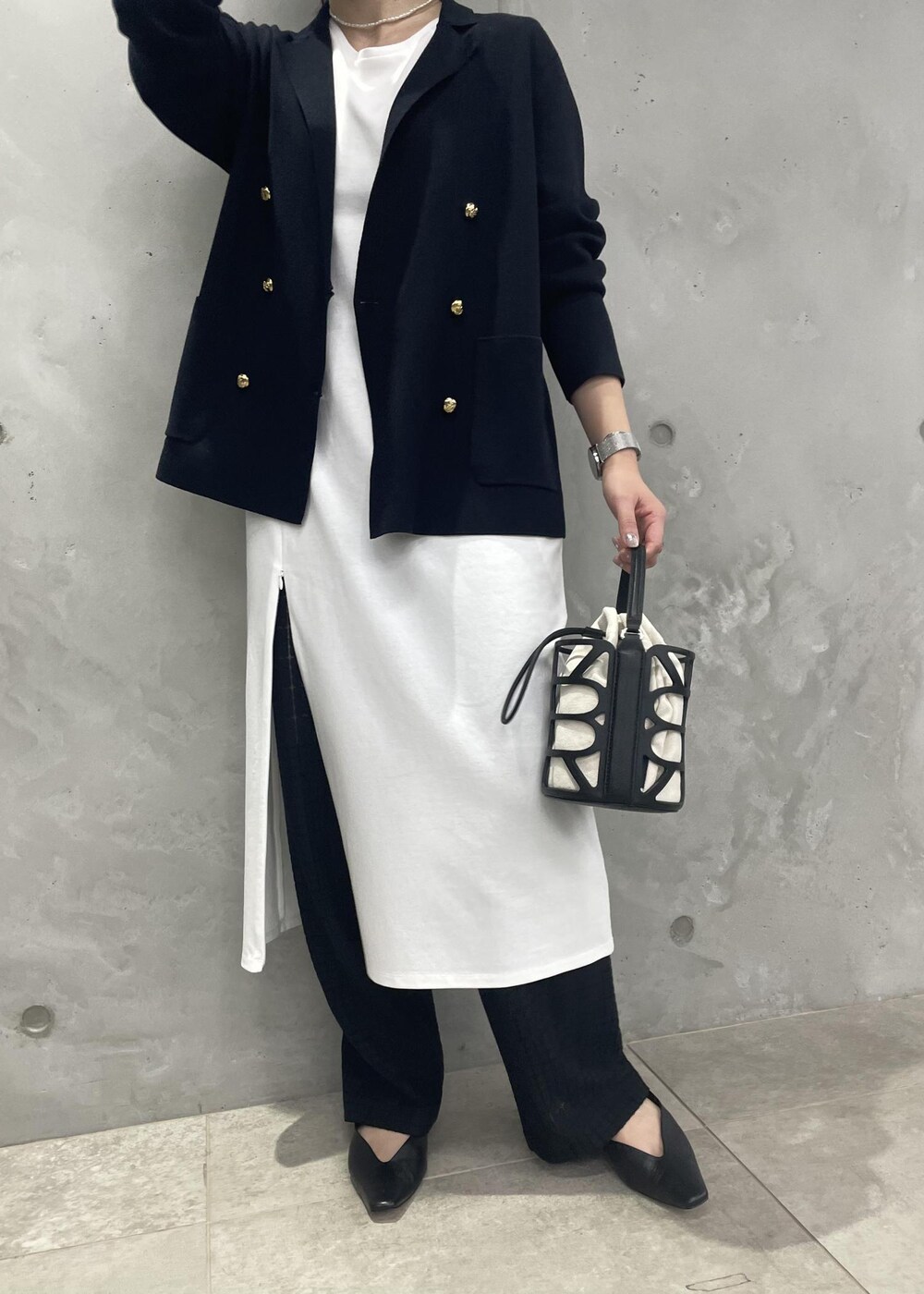 ブラック系のハンドバッグ、ブルー系のテーラードジャケット、ブラック系のその他パンツを着用したレディースの春コーディネートの5枚目の写真