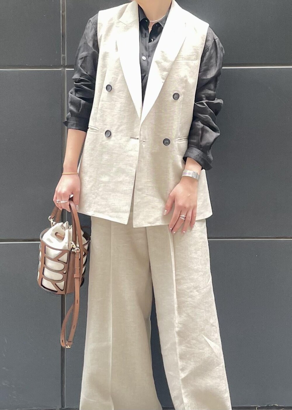 ブラック系のパンプス、ブラック系のシャツ/ブラウス、ベージュ系のベストを着用したレディースの春コーディネートの5枚目の写真