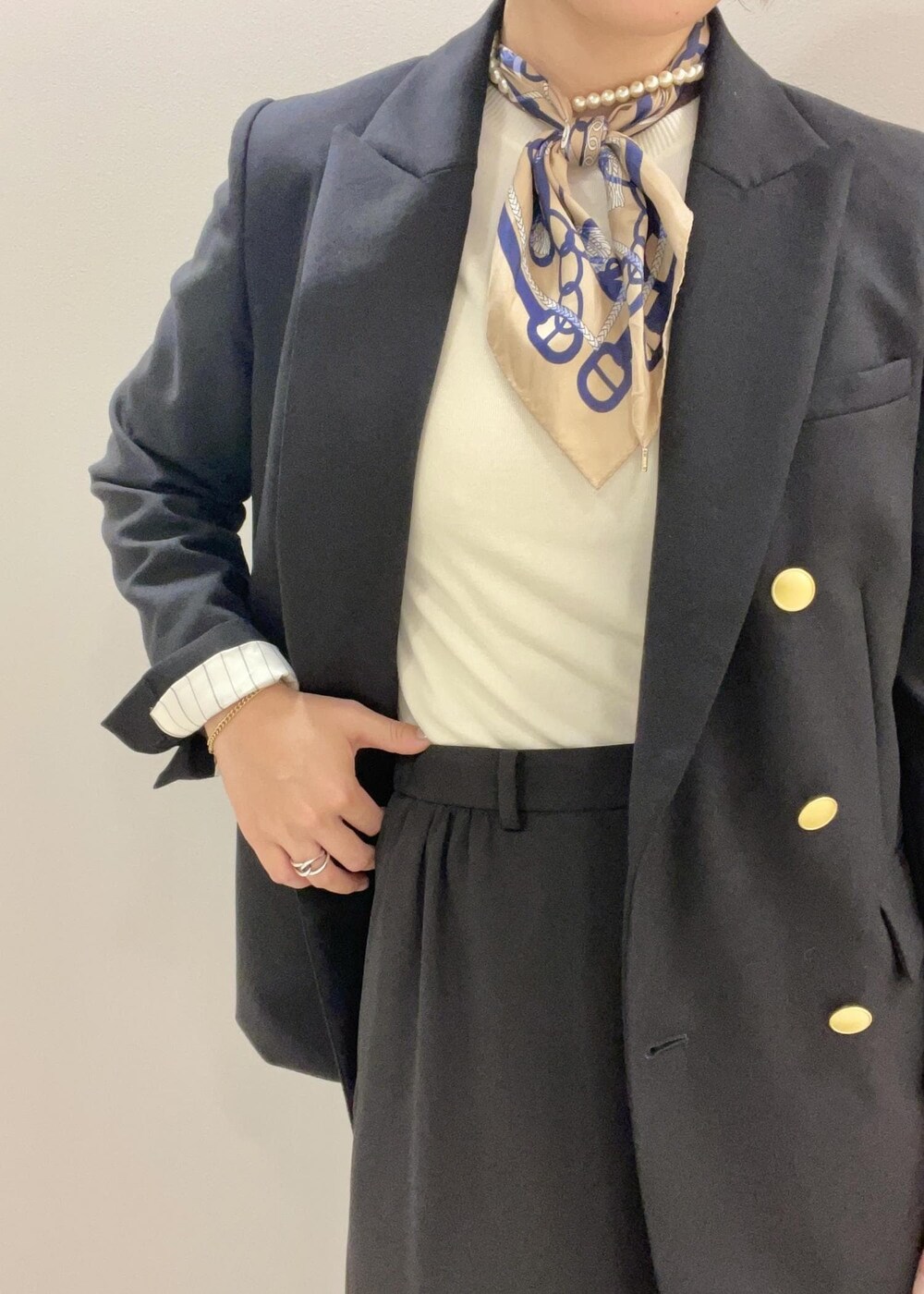 ブルー系のテーラードジャケット、イエロー系のハンドバッグ、ブラック系のブーツを着用したレディースの秋コーディネートの7枚目の写真