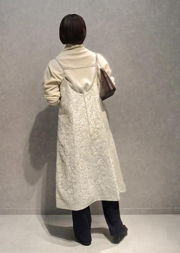 ブルー系のデニムパンツ、グレー系のハンドバッグ、ホワイト系のワンピースを着用したレディースの冬コーディネートの4枚目の写真