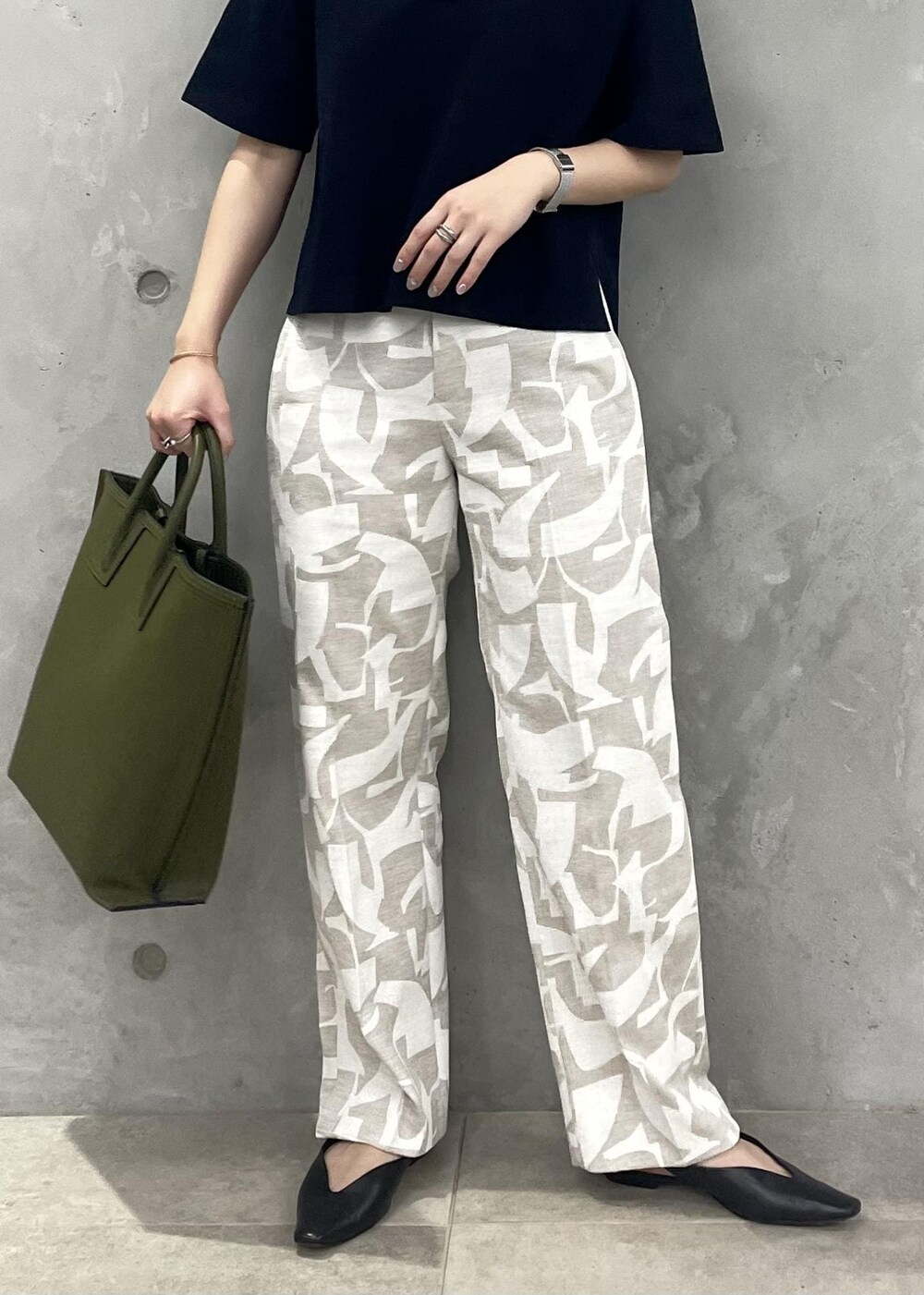 グリーン系のトートバッグ、ブラック系のパンプス、ブルー系のニット/セーターを着用したレディースの春コーディネートの8枚目の写真