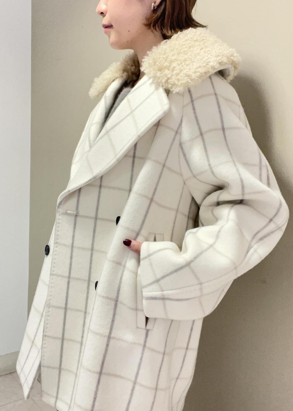 ホワイト系のチェスターコート、グリーン系のショルダーバッグ、ブラウン系のニット/セーターを着用したレディースの秋コーディネートの7枚目の写真