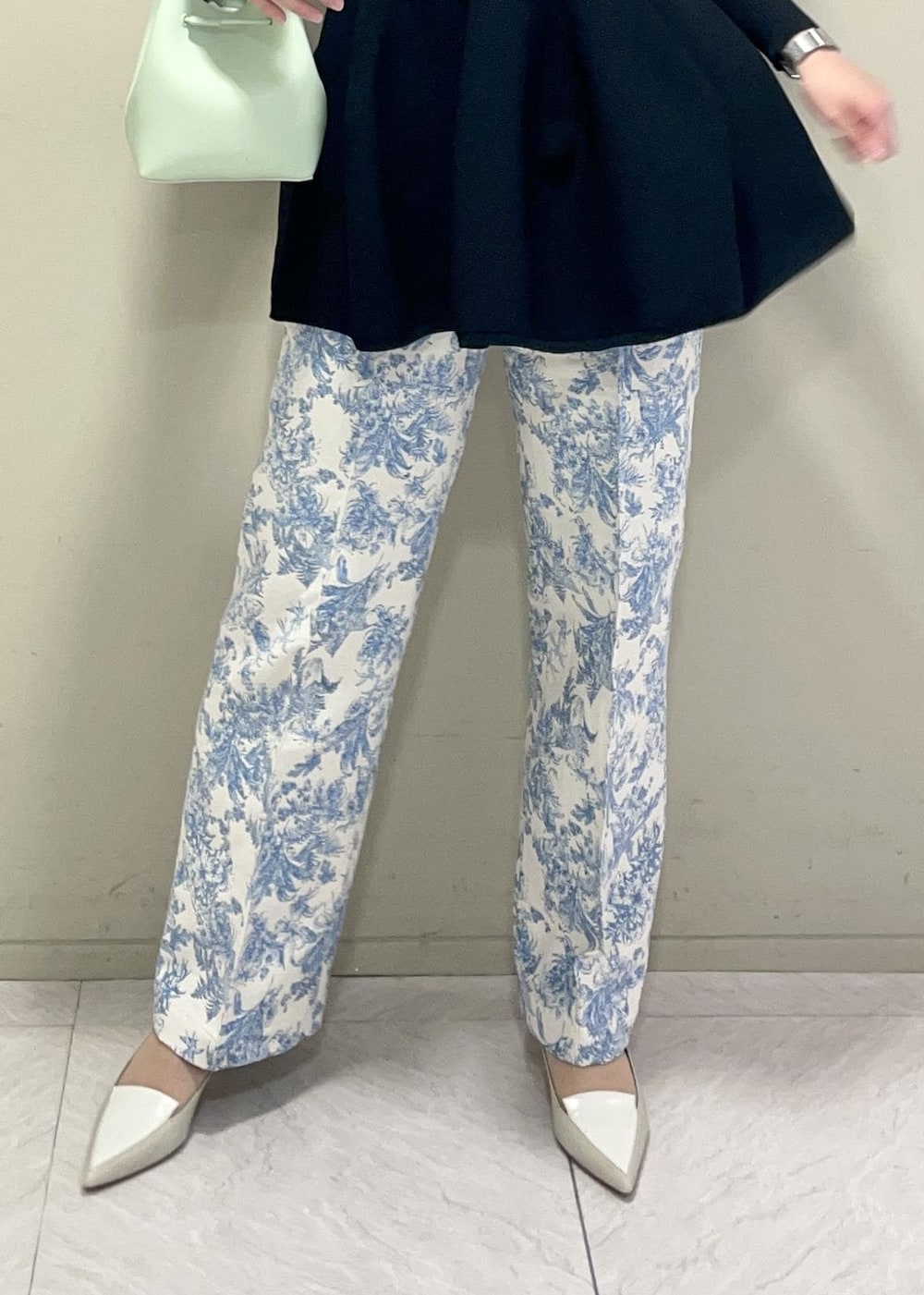 グリーン系のハンドバッグ、ブラック系のニット/セーター、ブルー系のその他パンツを着用したレディースの冬コーディネートの8枚目の写真