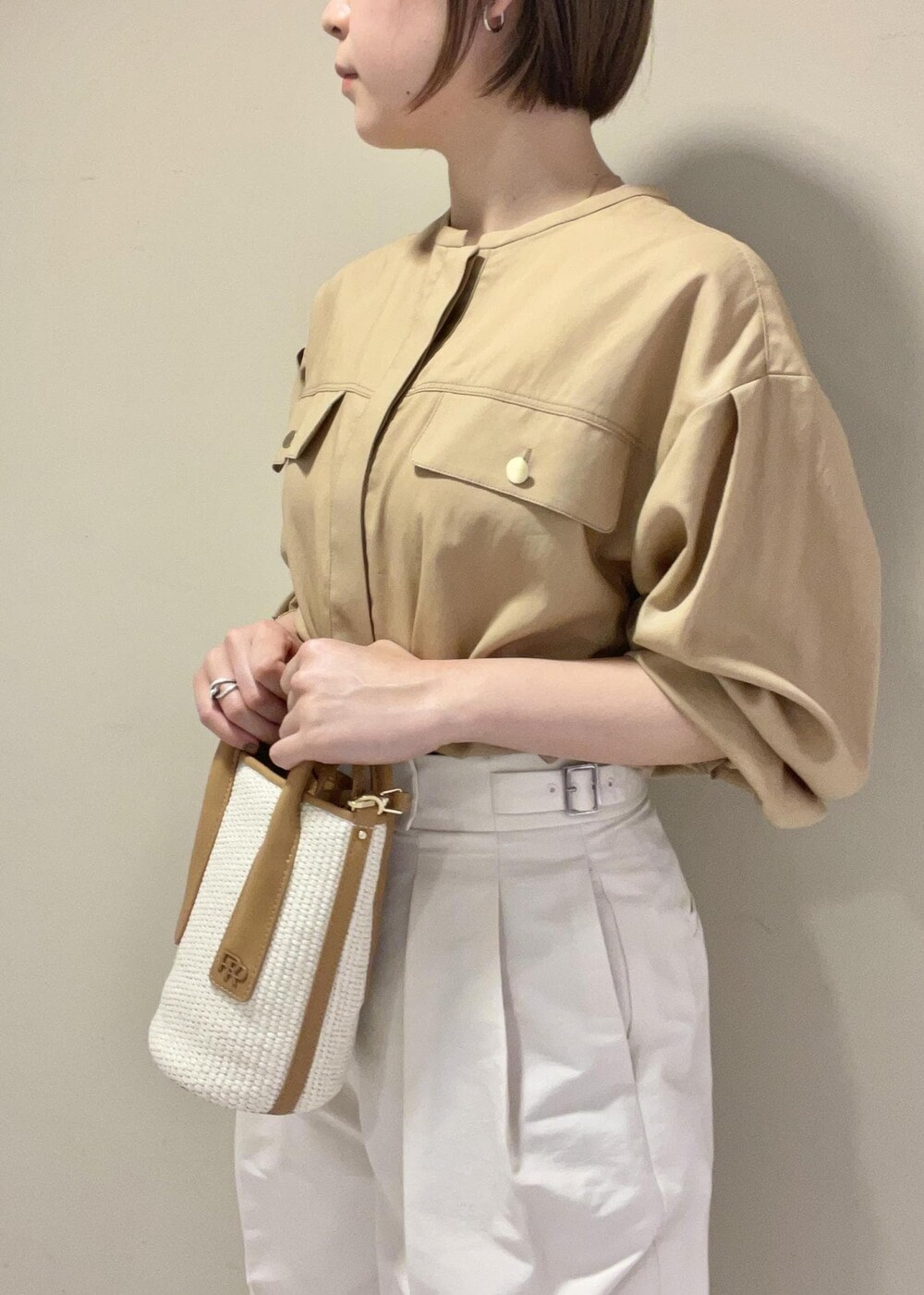 ブラック系のサンダル、ベージュ系のハンドバッグ、ホワイト系のその他パンツを着用したレディースの夏コーディネートの6枚目の写真