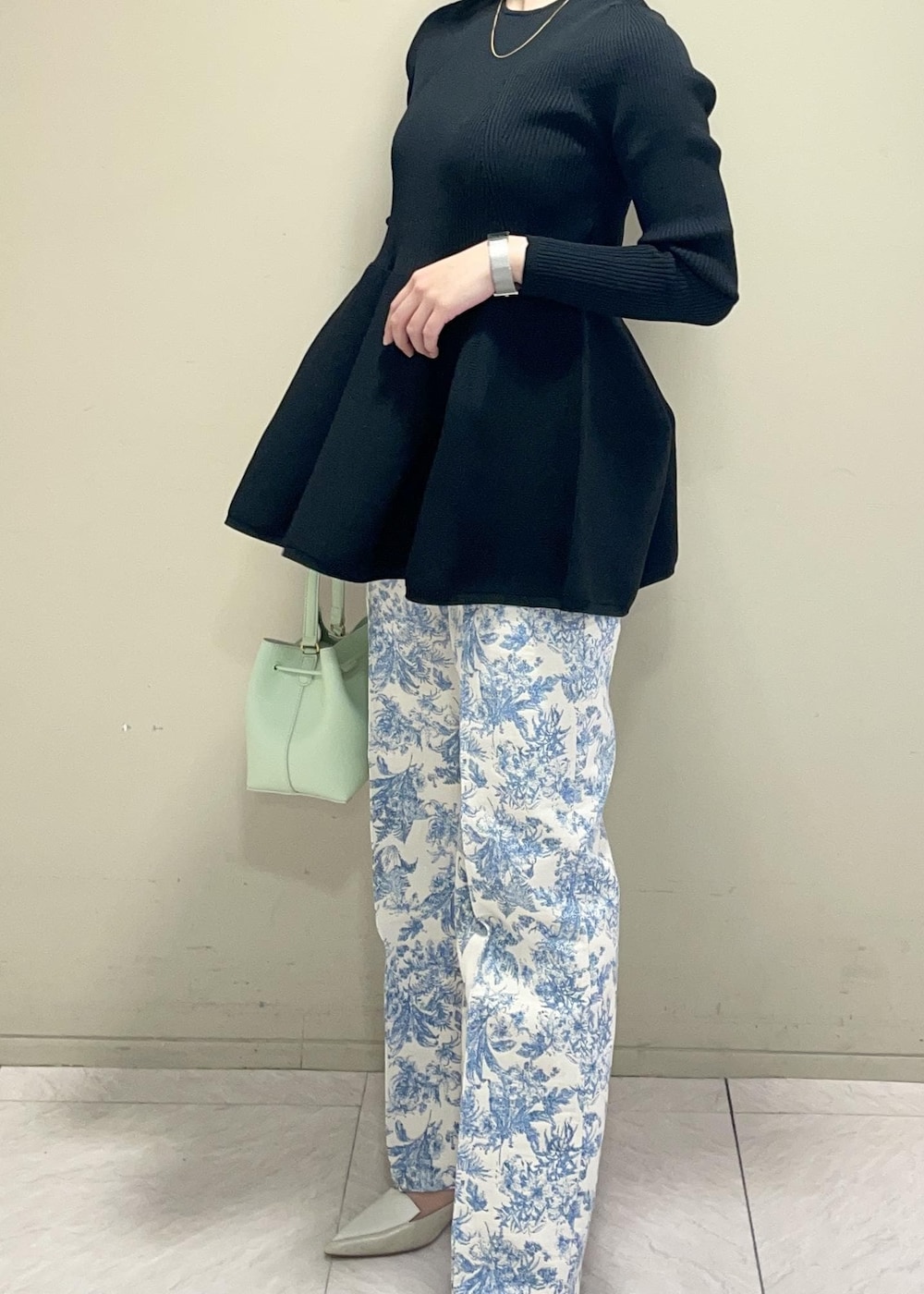 グリーン系のハンドバッグ、ブラック系のニット/セーター、ブルー系のその他パンツを着用したレディースの冬コーディネートの5枚目の写真