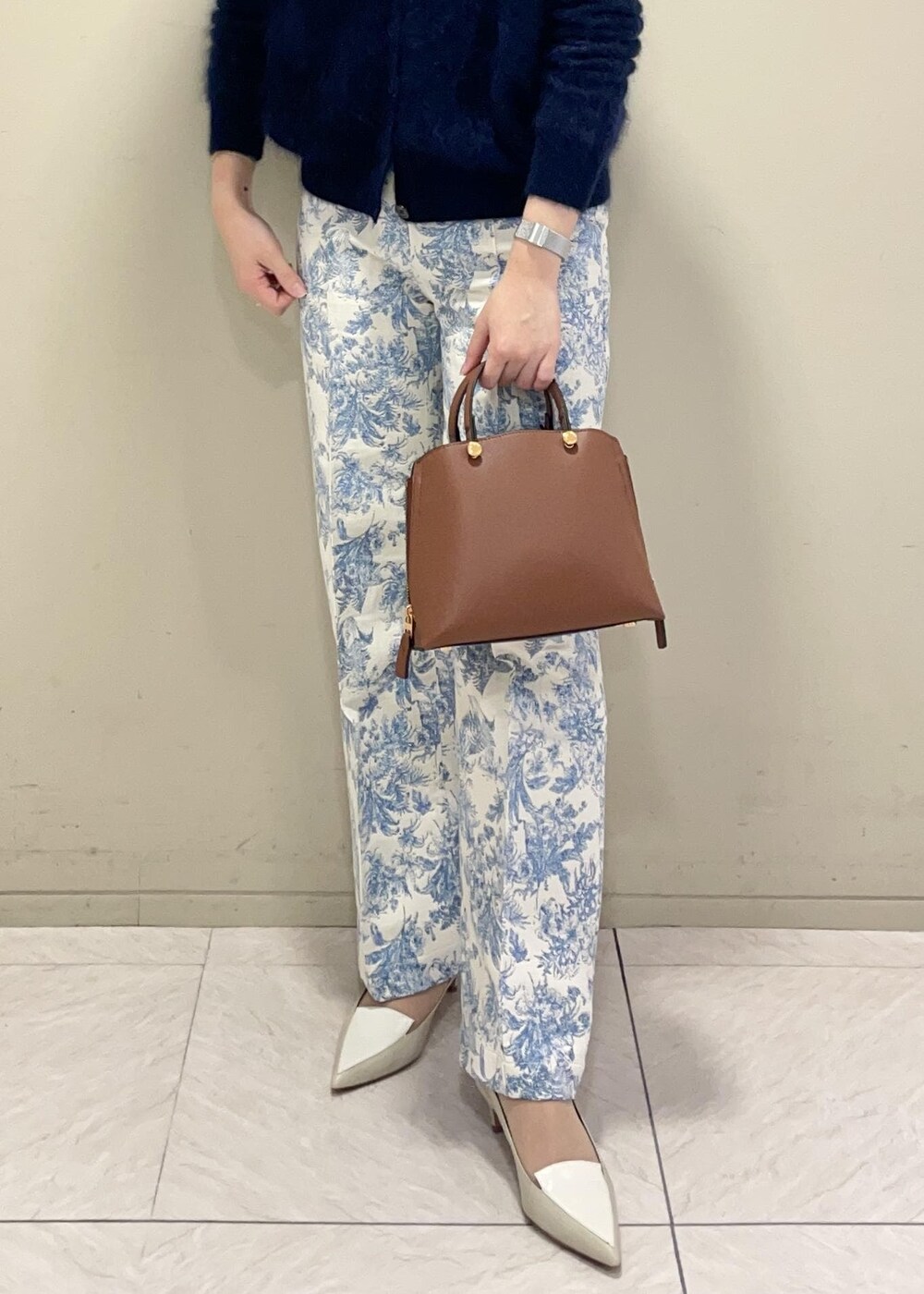 ブラウン系のハンドバッグ、ホワイト系のニット/セーター、ブルー系のその他パンツを着用したレディースの冬コーディネートの5枚目の写真