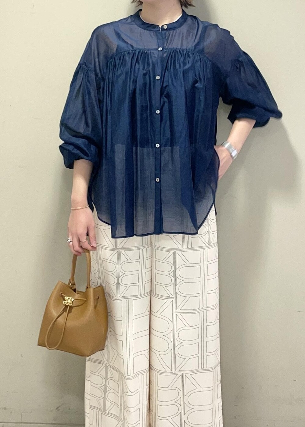 イエロー系のハンドバッグ、ホワイト系のその他パンツ、ブルー系のシャツ/ブラウスを着用したレディースの冬コーディネートの6枚目の写真