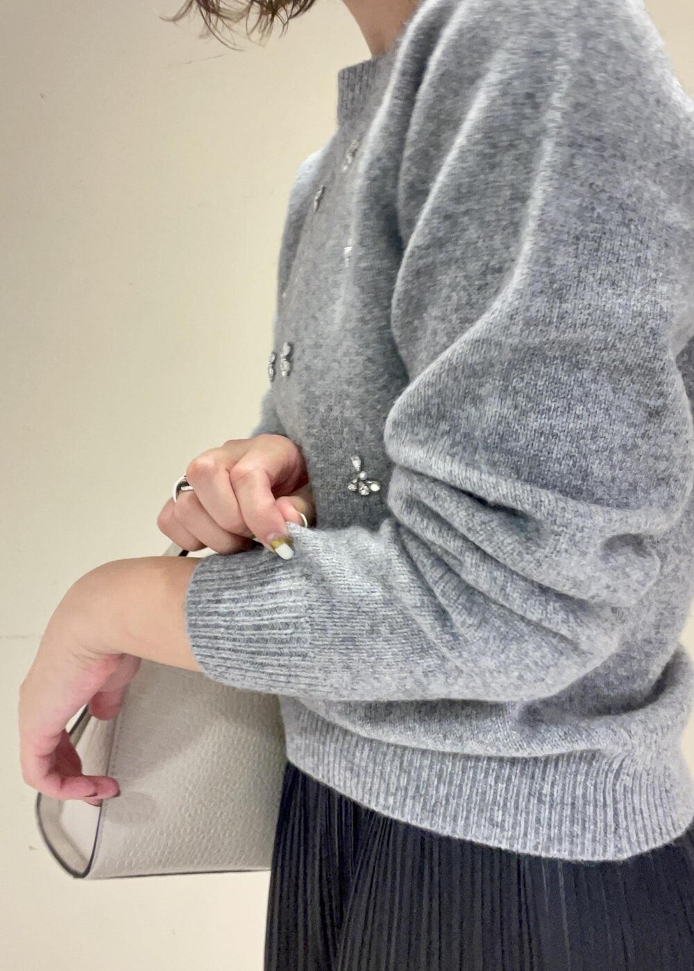 ブラック系のブーツ、ブラック系のスカート、ベージュ系のショルダーバッグを着用したレディースの秋コーディネートの7枚目の写真