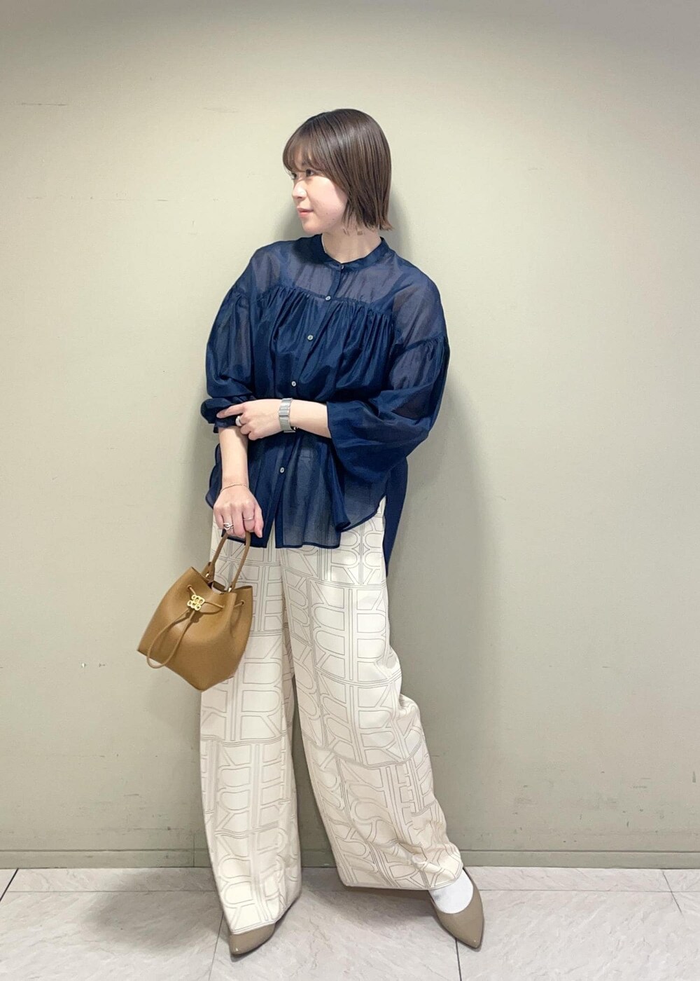 イエロー系のハンドバッグ、ホワイト系のその他パンツ、ブルー系のシャツ/ブラウスを着用したレディースの冬コーディネートの2枚目の写真