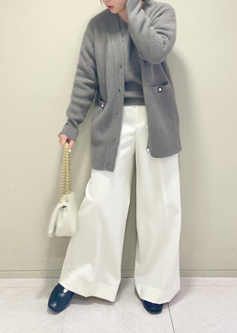 ホワイト系のハンドバッグ、ブラウン系のカーディガン/ボレロ、ブラウン系のニット/セーターを着用したレディースの秋コーディネートの6枚目の写真