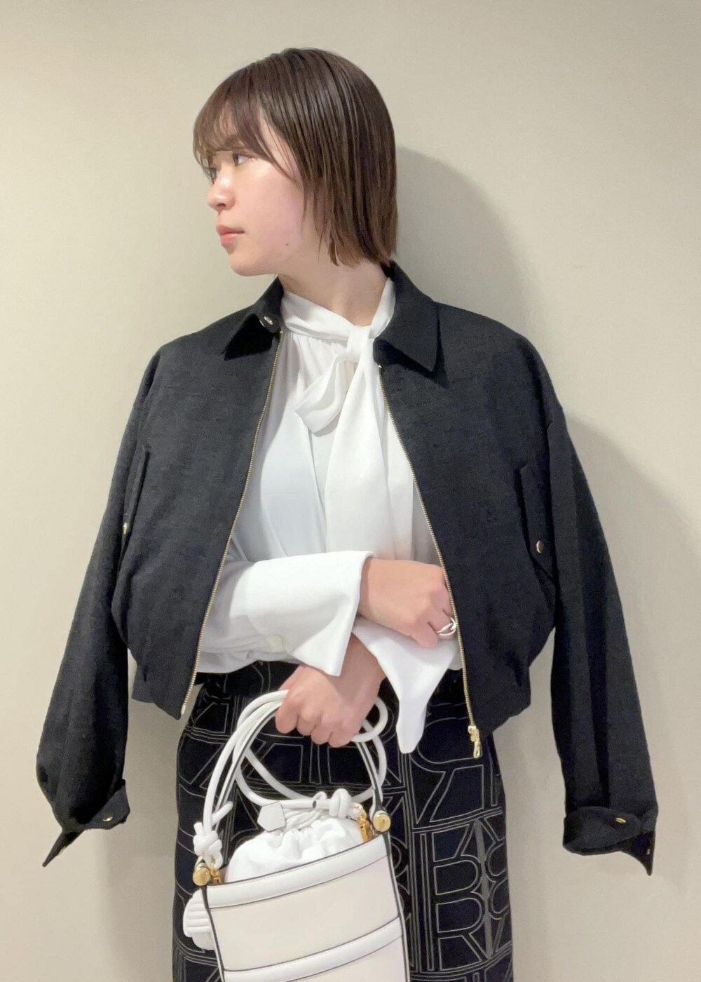 ホワイト系のハンドバッグ、ブラック系のその他パンツ、ブラック系のブルゾンを着用したレディースの冬コーディネートの5枚目の写真