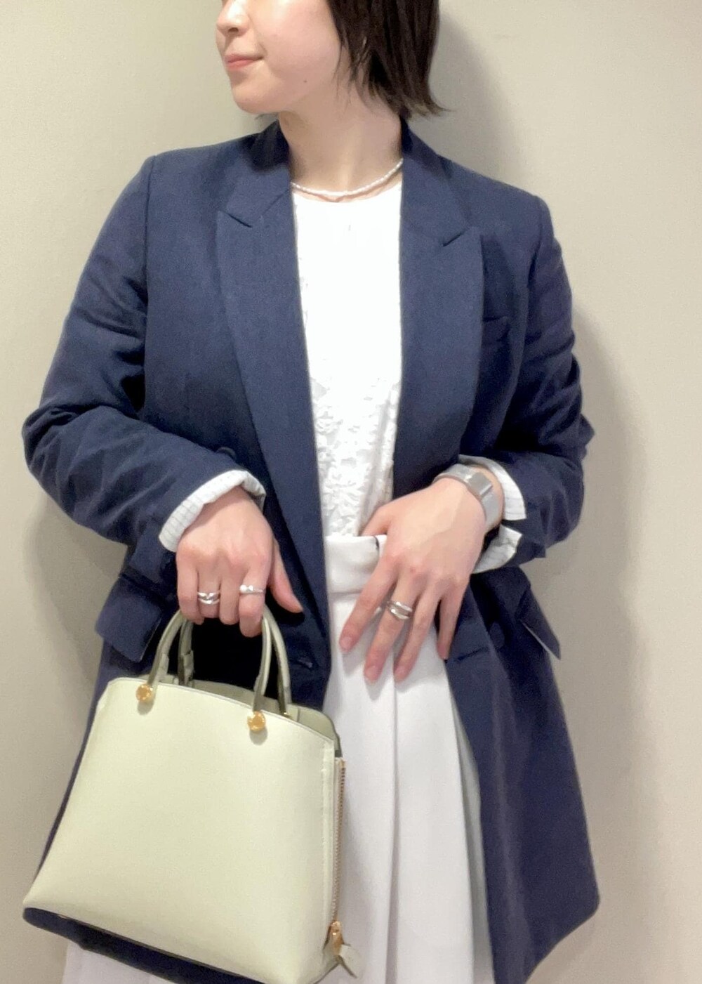 ホワイト系のその他パンツ、グリーン系のハンドバッグ、ブラック系のパンプスを着用したレディースの春コーディネートの5枚目の写真