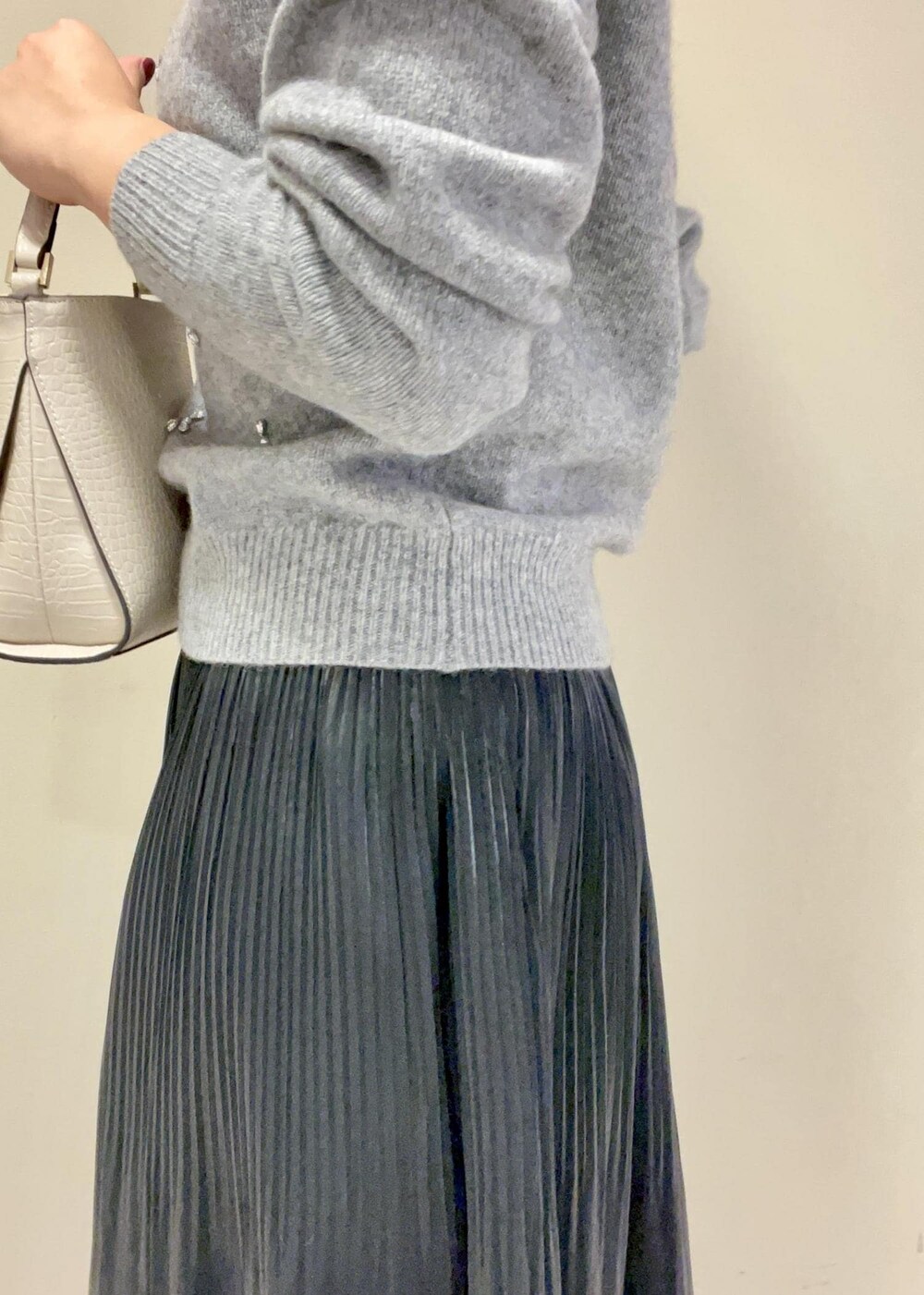 ブラック系のブーツ、ブラック系のスカート、ベージュ系のショルダーバッグを着用したレディースの秋コーディネートの8枚目の写真