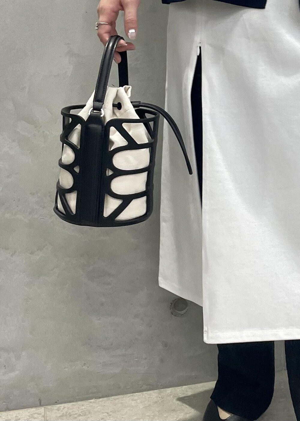 ブラック系のハンドバッグ、ブルー系のテーラードジャケット、ブラック系のその他パンツを着用したレディースの春コーディネートの9枚目の写真