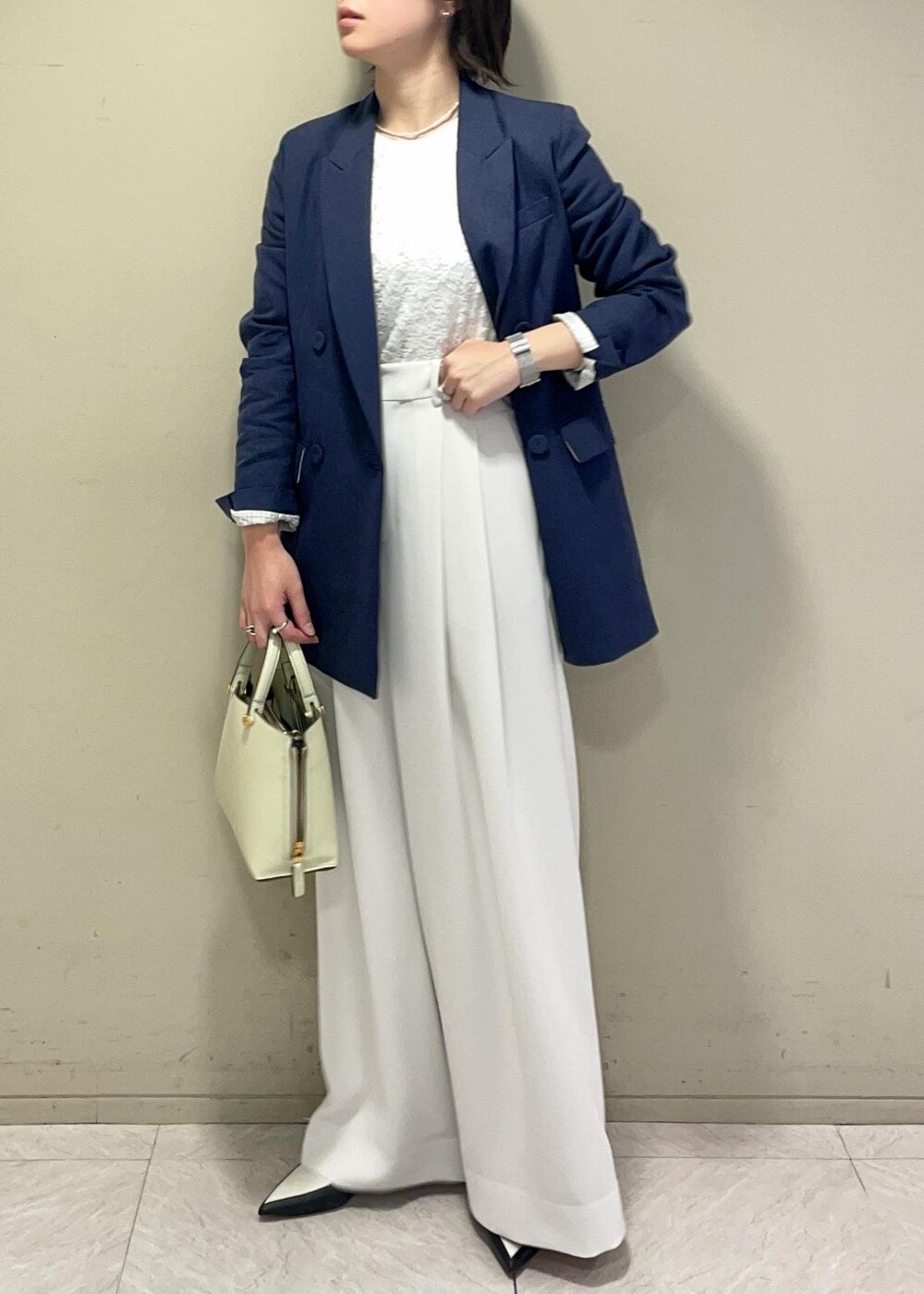 ホワイト系のその他パンツ、グリーン系のハンドバッグ、ブラック系のパンプスを着用したレディースの春コーディネートの2枚目の写真