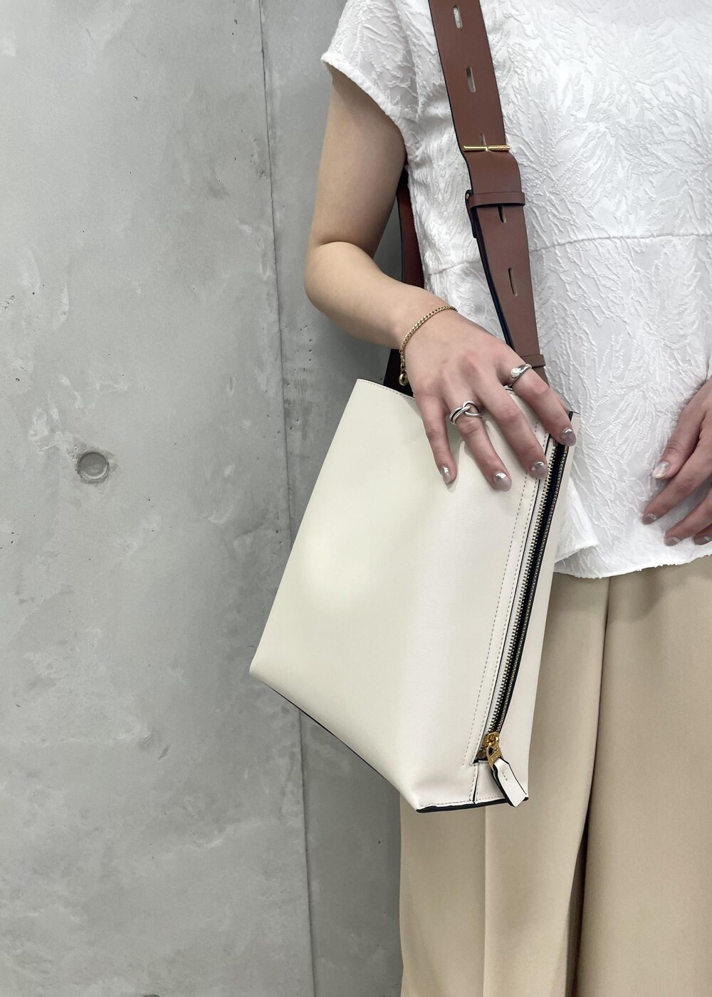 ホワイト系のショルダーバッグ、ブラック系のパンプス、ホワイト系のシャツ/ブラウスを着用したレディースの春コーディネートの10枚目の写真