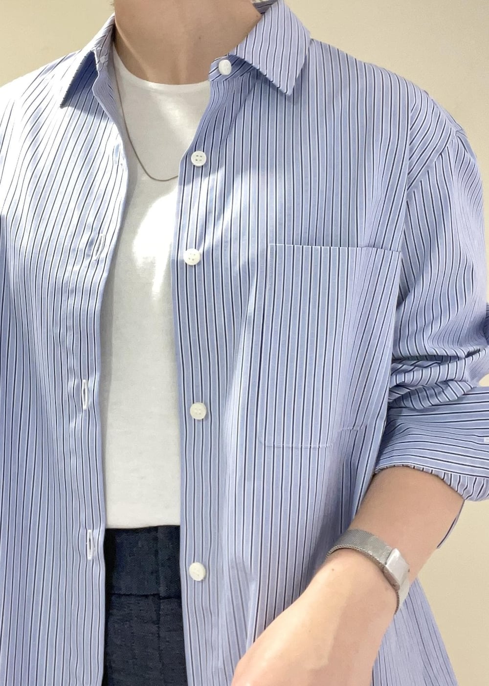 ホワイト系のハンドバッグ、ブルー系のデニムパンツ、ブルー系のシャツ/ブラウスを着用したレディースの春コーディネートの8枚目の写真