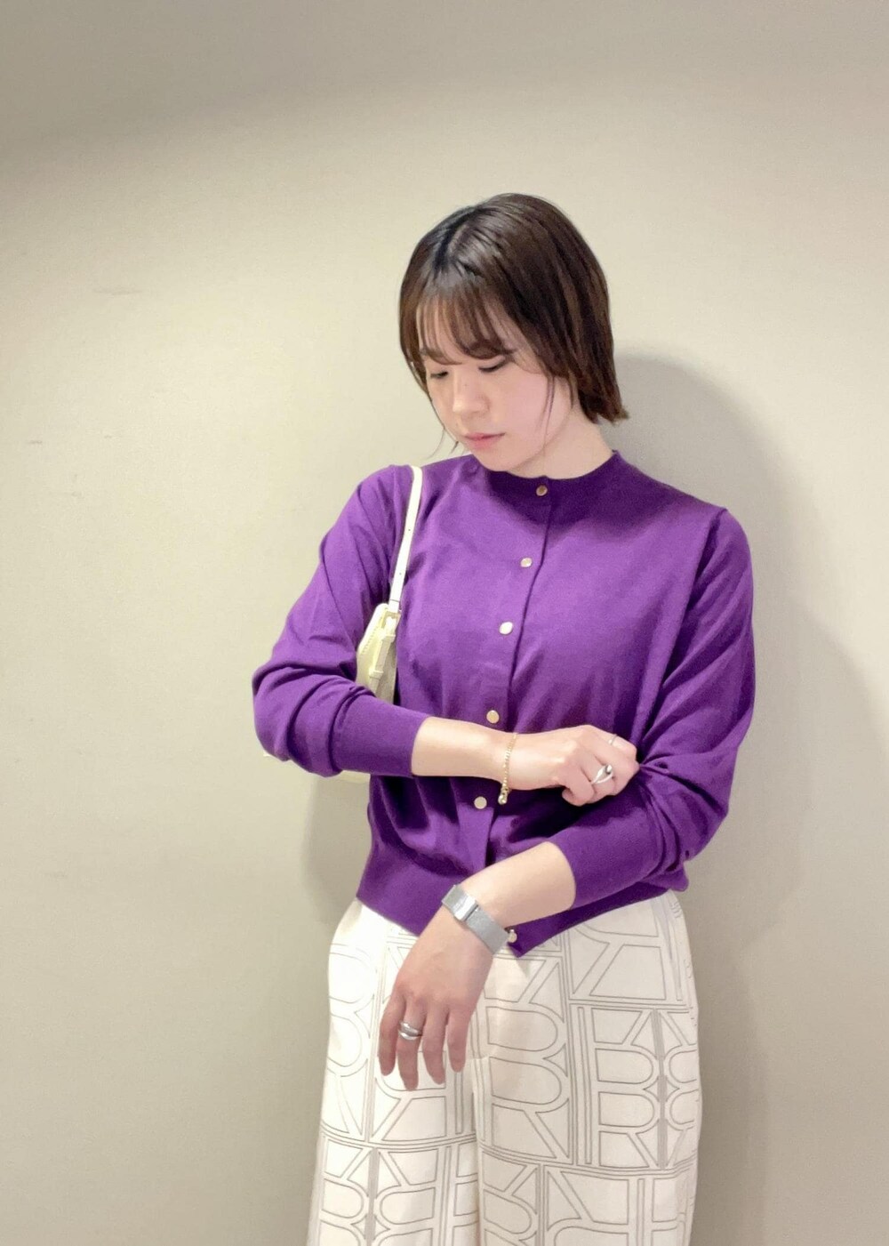 ベージュ系のハンドバッグ、ホワイト系のその他パンツ、パープル系のカーディガン/ボレロを着用したレディースの冬コーディネートの6枚目の写真