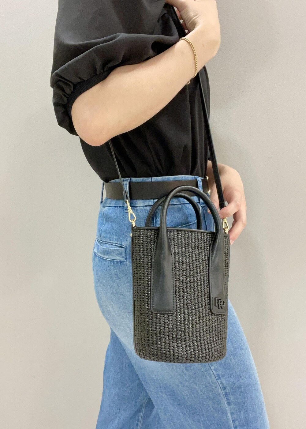 ブラック系のサンダル、ブラック系のハンドバッグ、ブラック系のTシャツ/カットソーを着用したレディースの夏コーディネートの6枚目の写真