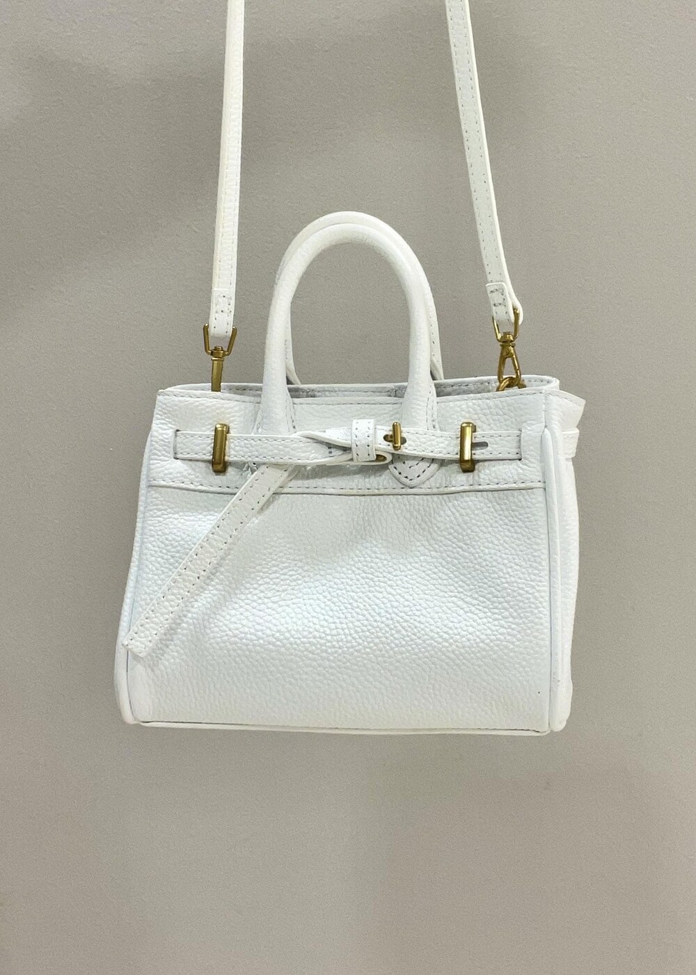 ホワイト系のハンドバッグ、ホワイト系のTシャツ/カットソー、ブルー系のテーラードジャケットを着用したレディースの夏コーディネートの7枚目の写真