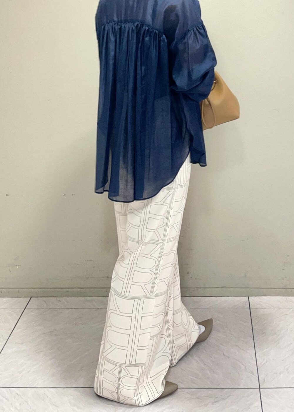 イエロー系のハンドバッグ、ホワイト系のその他パンツ、ブルー系のシャツ/ブラウスを着用したレディースの冬コーディネートの8枚目の写真