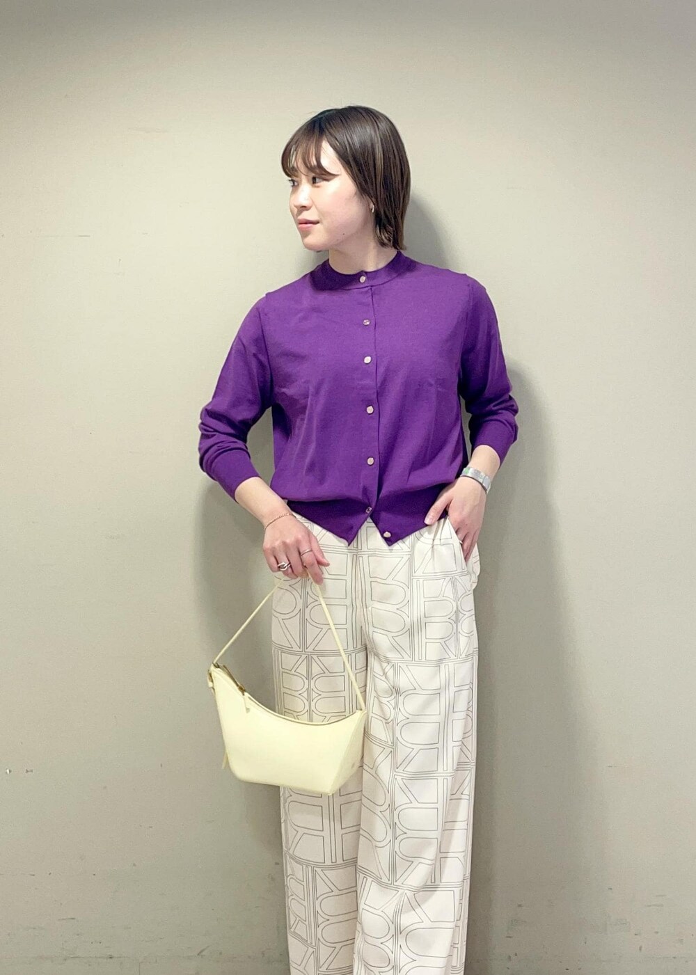 ベージュ系のハンドバッグ、ホワイト系のその他パンツ、パープル系のカーディガン/ボレロを着用したレディースの冬コーディネートの5枚目の写真