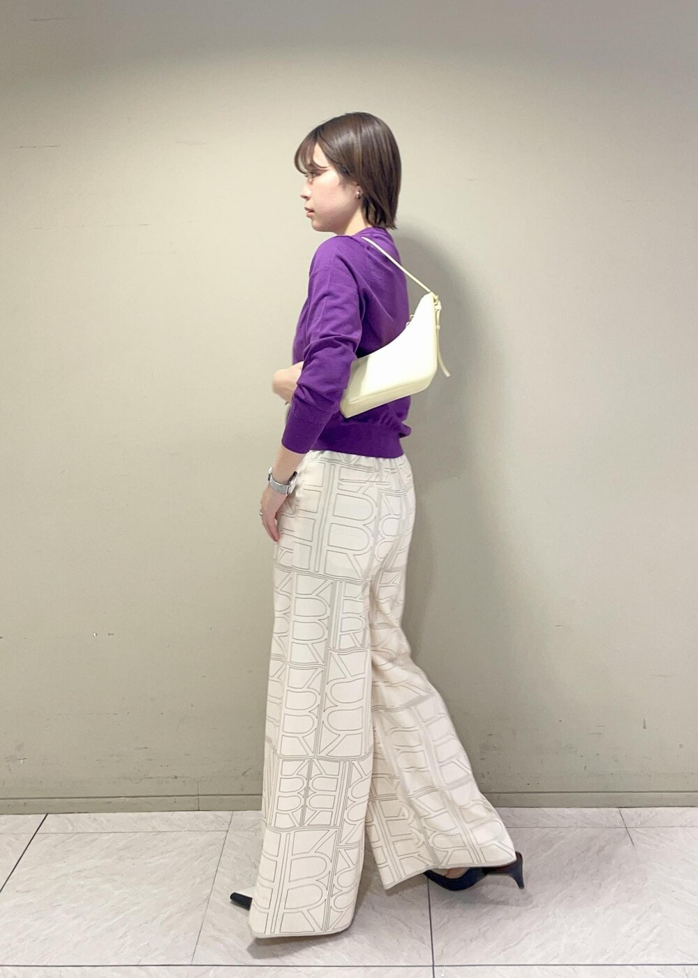 ベージュ系のハンドバッグ、ホワイト系のその他パンツ、パープル系のカーディガン/ボレロを着用したレディースの冬コーディネートの3枚目の写真