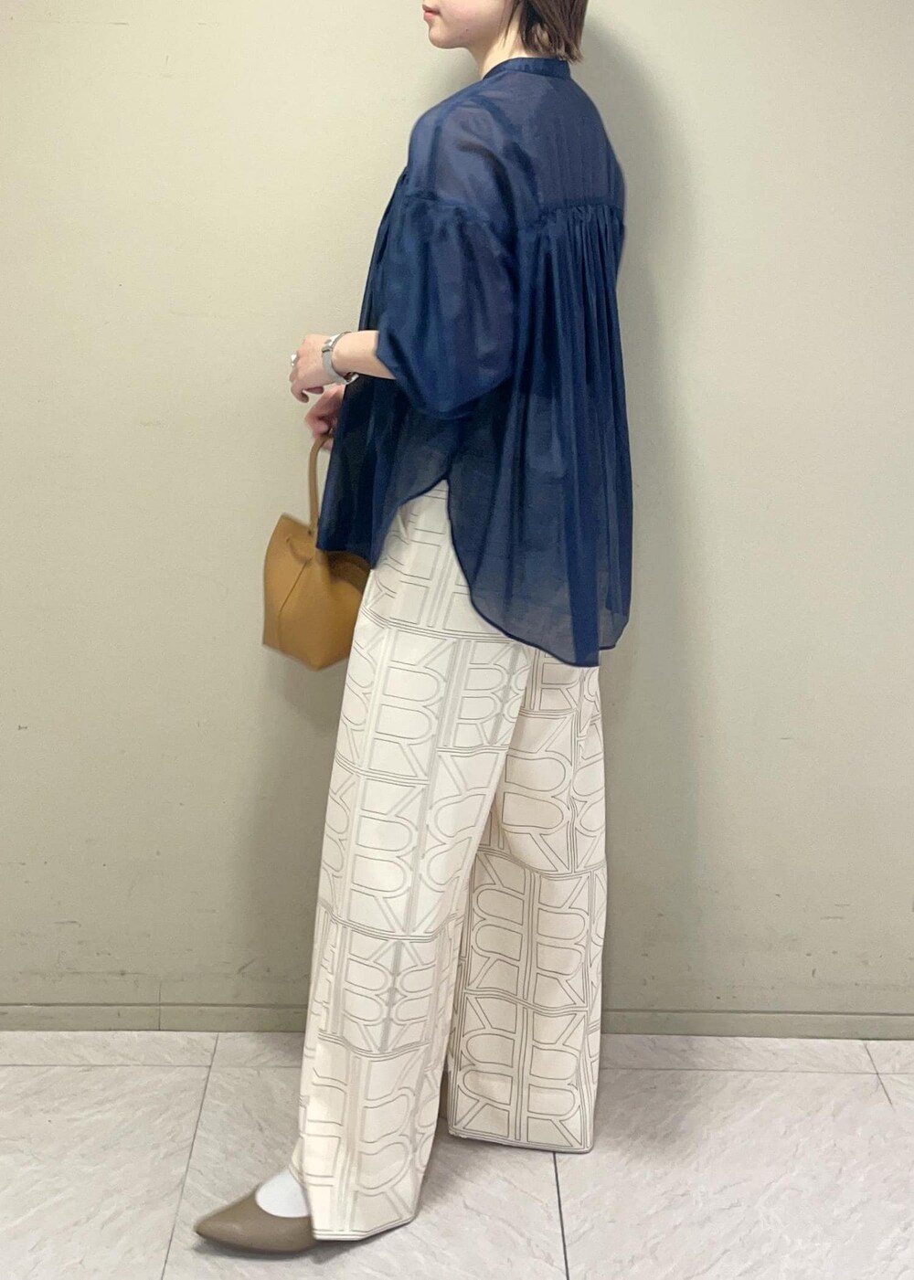 イエロー系のハンドバッグ、ホワイト系のその他パンツ、ブルー系のシャツ/ブラウスを着用したレディースの冬コーディネートの4枚目の写真