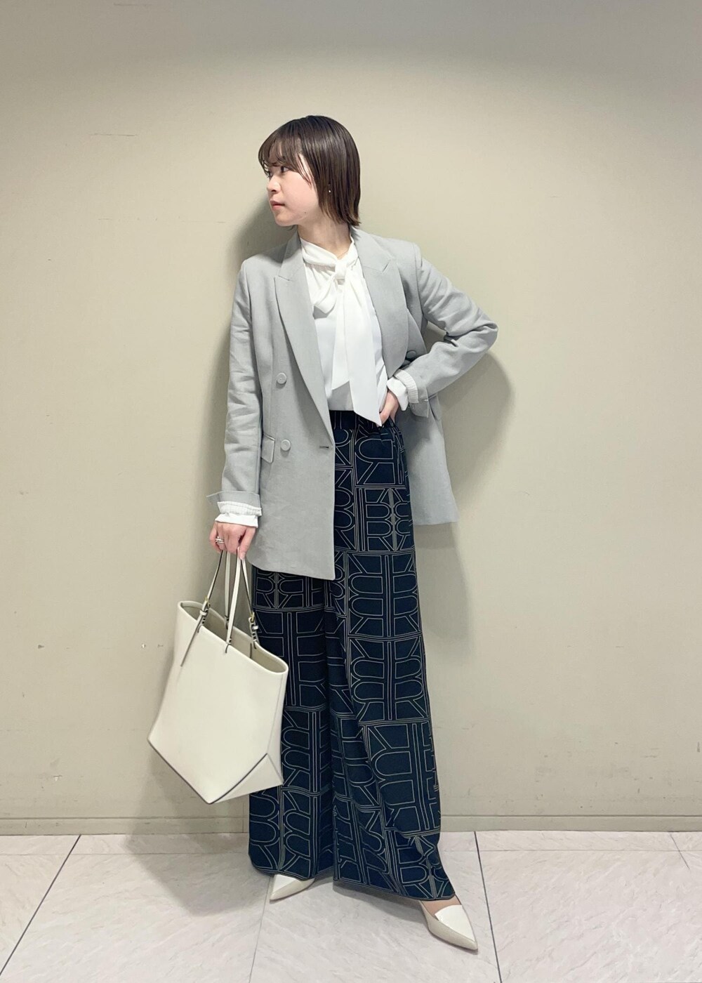 ブラック系のその他パンツ、ホワイト系のシャツ/ブラウス、ホワイト系のトートバッグを着用したレディースの冬コーディネートの3枚目の写真