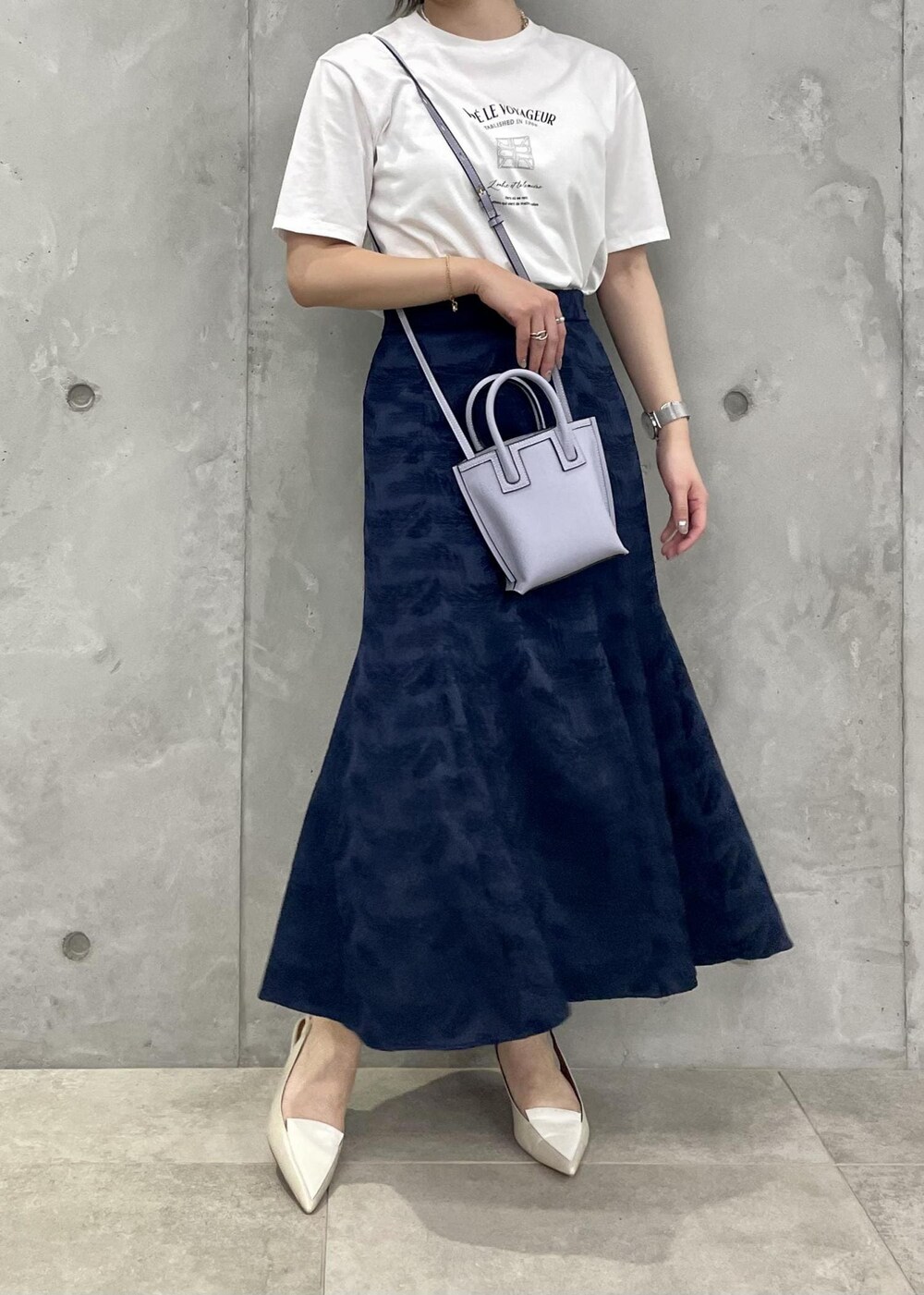 ベージュ系のパンプス、ブルー系のスカート、ホワイト系のTシャツ/カットソーを着用したレディースの春コーディネートの3枚目の写真