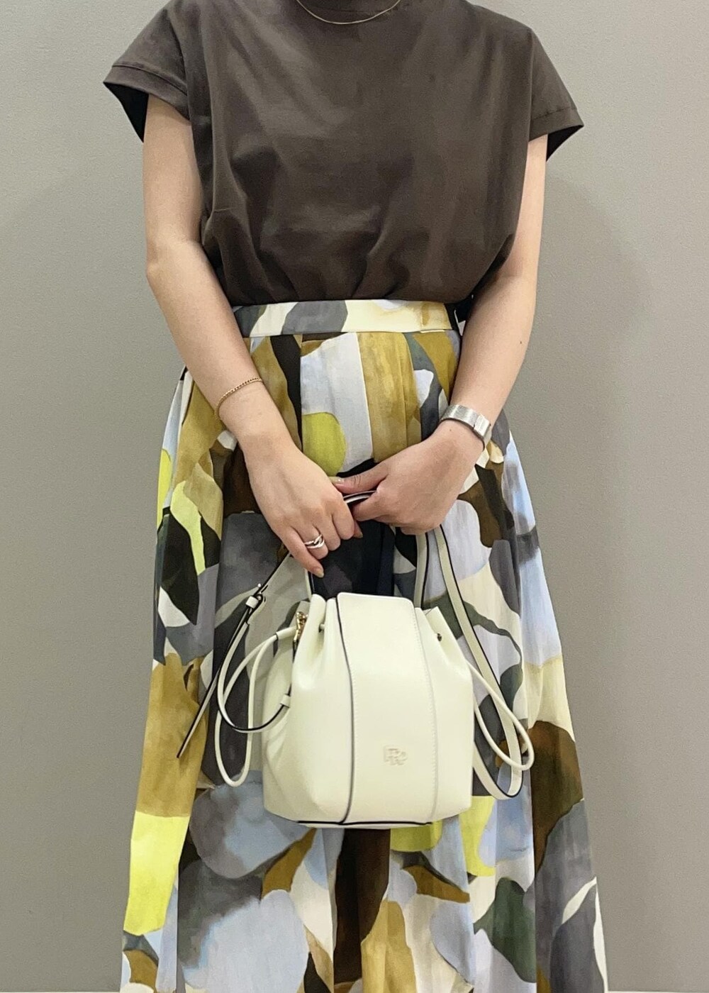 ホワイト系のハンドバッグ、グリーン系のTシャツ/カットソー、ブルー系のスカートを着用したレディースの夏コーディネートの5枚目の写真
